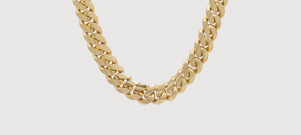 Alt=" close up picture a gold Cuban link chain with the goldzenn blue color background"