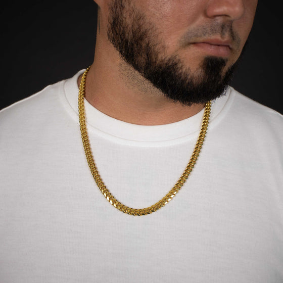 7mm - Cuban Link- 14k Gold Bonded| GOLDZENN- Showing how it looks on a white shirt.