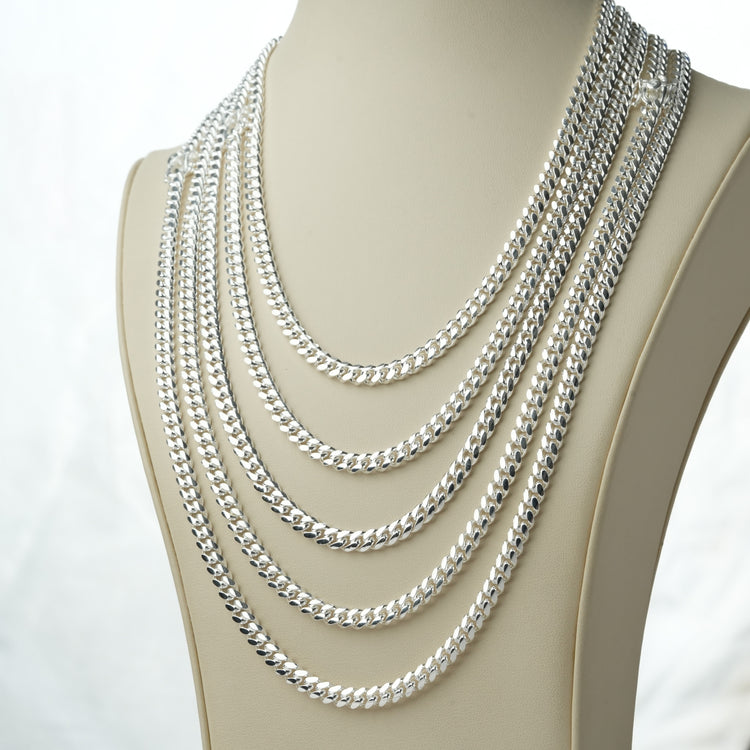Five 6mm 925 Sterling Silver Cuban link chains displayed on a cream jewelry bust against a white background
