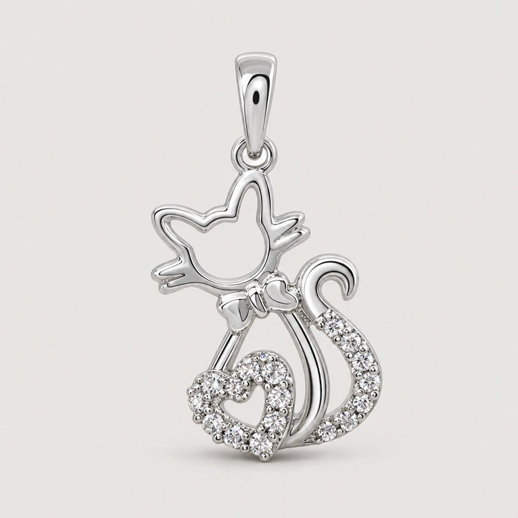 The 1/10 CTW Diamond Heart Cat Pendant in 10K Gold is perfect for cat lovers, featuring a gold cat outline with a heart-shaped, diamond-accented tail tip, shown on a plain warm off-white studio background.