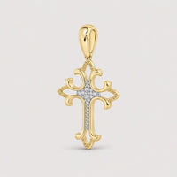The 1/12CTW Diamond Fashion Cross Pendant in 10K gold features decorative curved edges, natural diamonds at the center, and a matching gold bail—an elegant jewelry piece shown against a plain warm off-white studio background.