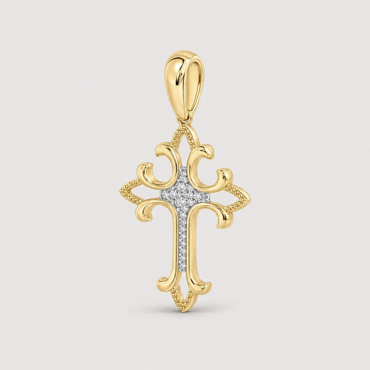 The 1/12CTW Diamond Fashion Cross Pendant in 10K gold features decorative curved edges, natural diamonds at the center, and a matching gold bail—an elegant jewelry piece shown against a plain warm off-white studio background.