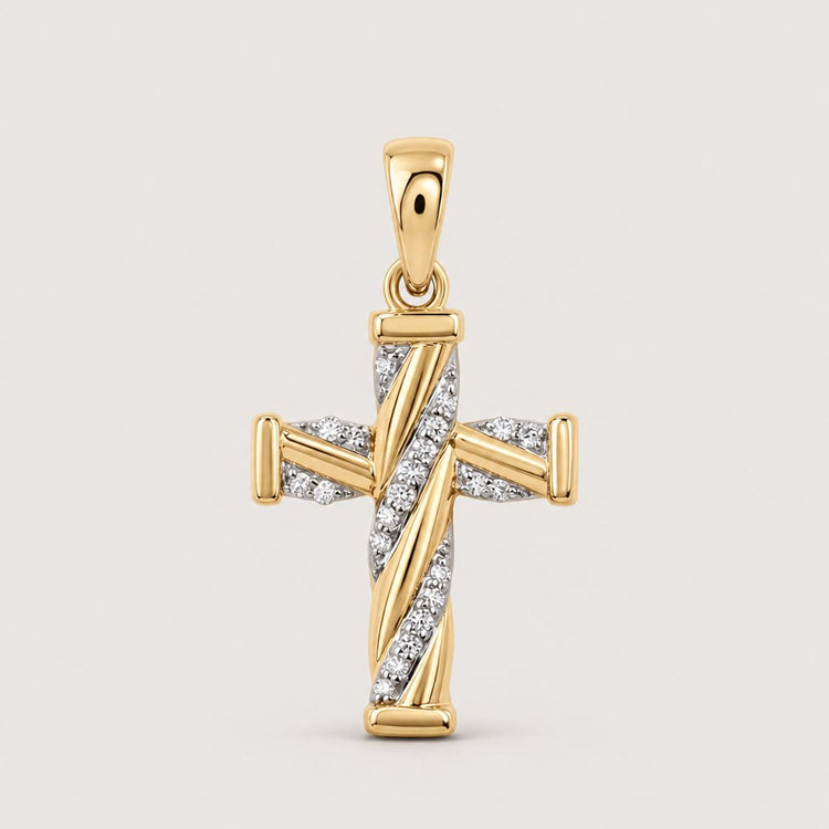 The 1/20 CTW Diamond Cross Pendant in 10K Gold features diagonal rows of natural diamonds at the center and a polished gold bail for easy attachment to a chain, shown on a plain warm off-white studio background.
