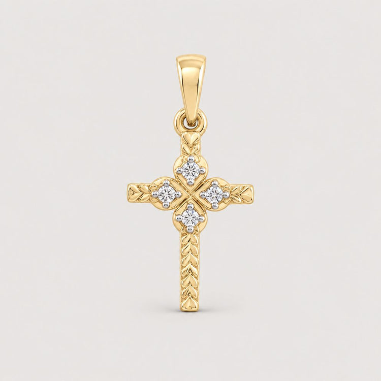 The 1/20CTW Natural Diamond Cross Pendant in 10K gold showcases an engraved pattern with five round natural diamonds on the center and arms, displayed against a warm off-white studio background.