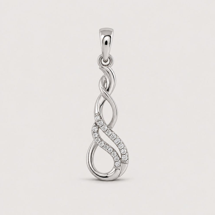 A 1/20 CTW Diamond Infinity Pendant in 10k Gold features two intertwined loops—one accented with sparkling diamonds—creating an elegant and modern design against a plain warm off-white studio background.