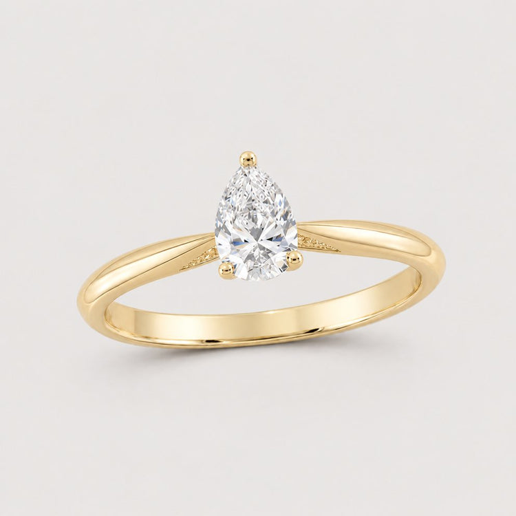 The 1/2CT Pear Diamond Solitaire Ring in 14k Gold features a natural pear diamond set in a prong on a slim gold band.