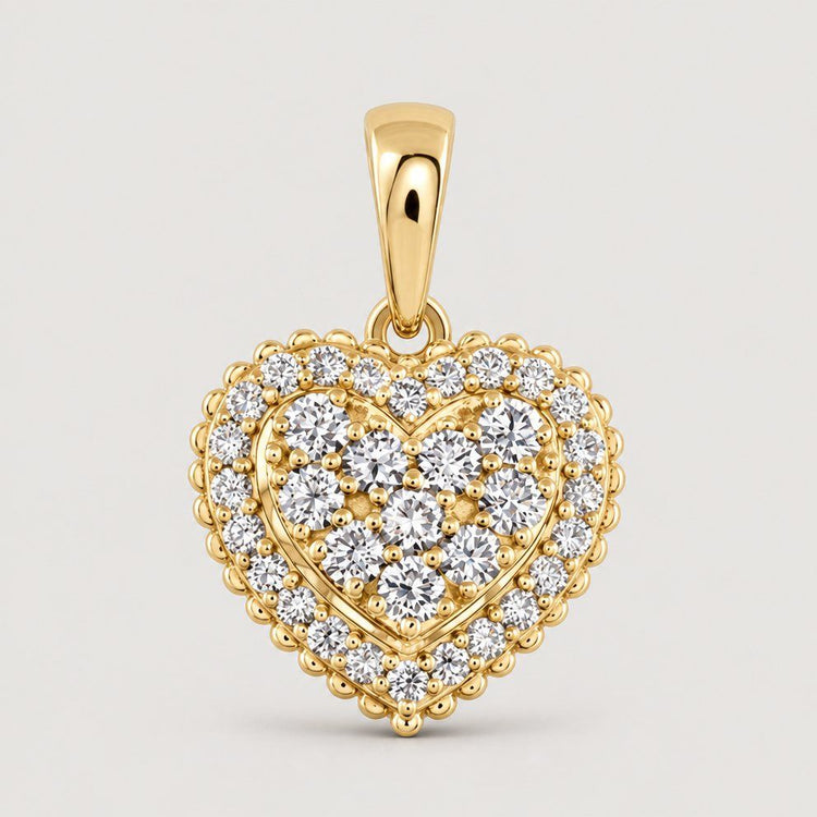 The 1/2 CTW Diamond Heart Pendant in 14K Gold dazzles with sparkling white diamonds, a decorative scalloped border, and a gold bail—an elegant choice to enhance any necklace.