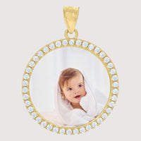 A 10K Solid Gold Custom Picture Pendant with CZ Stones frames a photo of a smiling baby wrapped in a white towel, the light background highlighting the baby's sweet expression—personalized jewelry at its finest.