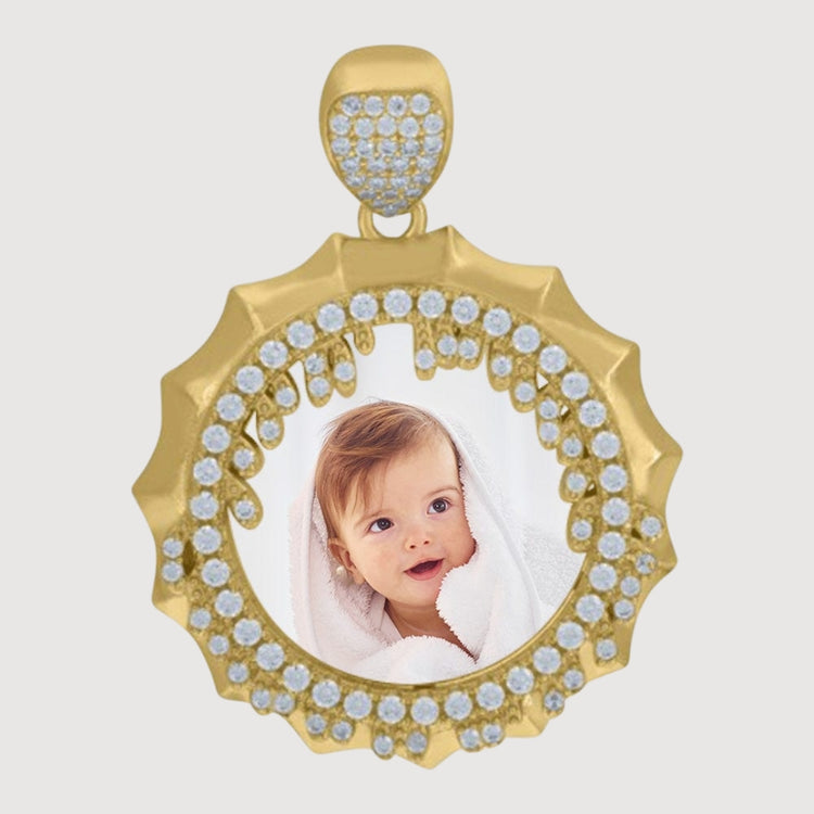 The 10k Gold Picture Pendant with CZ Stone Cluster frames a baby’s photo wrapped in a white towel, creating memorable personalized jewelry on a plain background.
