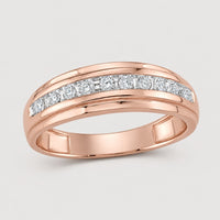 A 10k two-tone gold diamond wedding band – 1/4 cttw, featuring a row of round white diamonds set in a channel across the top, displayed on a plain warm off-white studio background.
