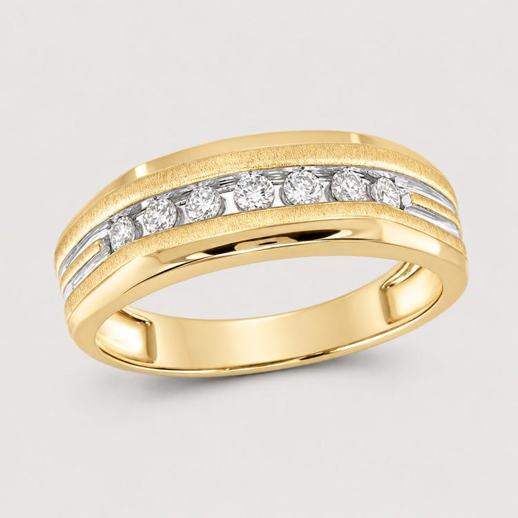 The 10k Two-Tone Gold Diamond Grooved Wedding Band 1/4 Cttw features a central row of round diamonds set between polished and brushed gold bands, making it a timeless diamond wedding band. Displayed on a warm off-white studio background.