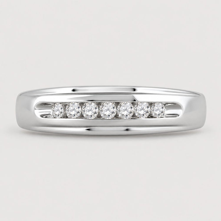 The 10k White Gold Round Diamond Wedding Band 1/4 Cttw features a row of seven round diamonds set horizontally in a channel across the center, shown on a warm off-white studio background.