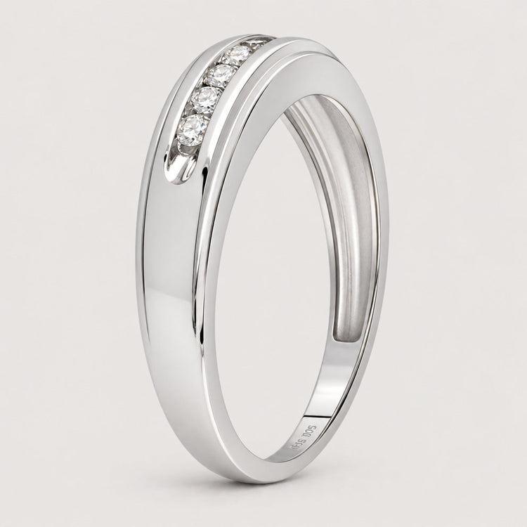 The 10k White Gold Round Diamond Wedding Band 1/4 Cttw features three small, round diamonds set in a smooth, slightly curved band, shown against a plain warm off-white studio background.