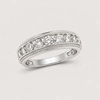A 10k gold round diamond band ring with a row of sparkling diamonds, totaling 2 CTTW, each set in a bezel setting and displayed on a warm off-white studio background.
