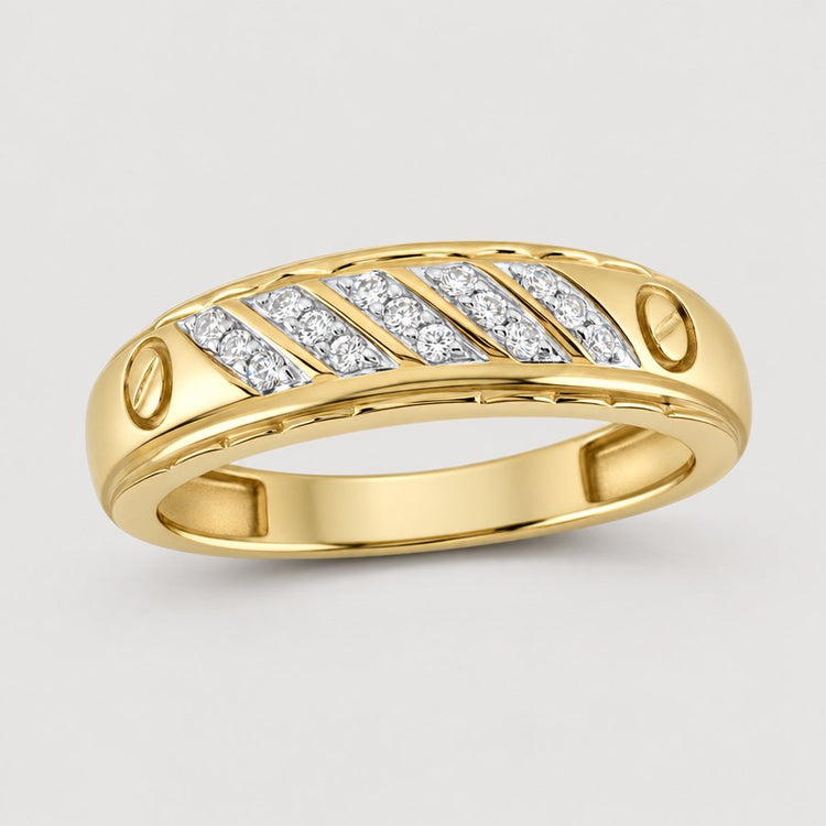 The 10K Yellow Gold 1/5 CTW Diamond Wedding Band features a row of diagonal inset diamonds and engraved oval accents, displayed on a warm off-white studio background with a subtle contact shadow—an elegant and unique choice for your special day.
