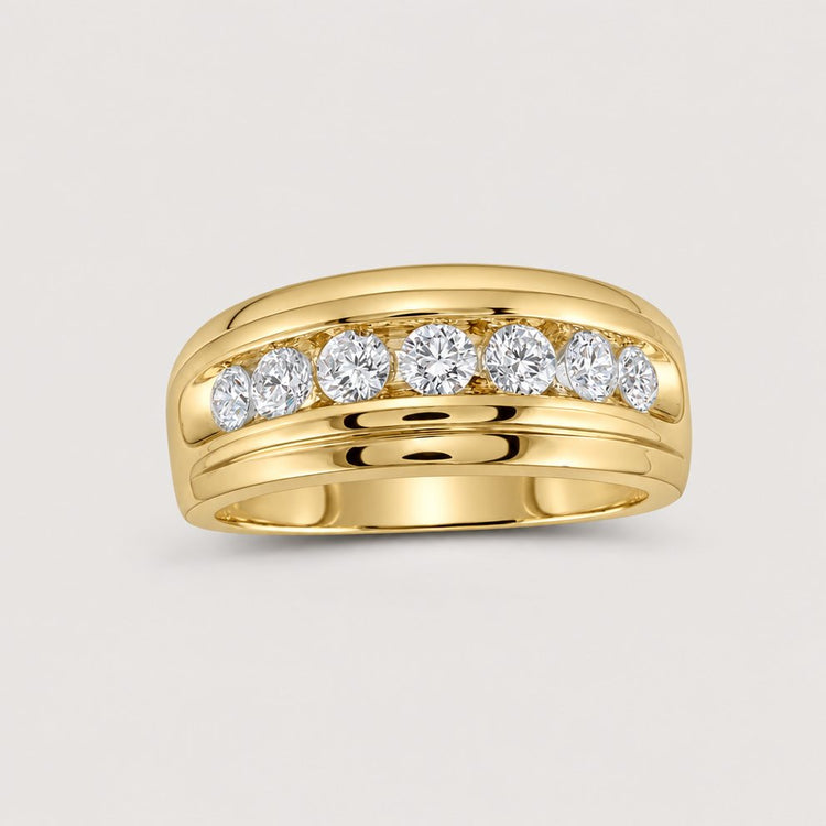 The 10k Gold Diamond Channel-Set Wedding Band Ring 1 Cttw features a wide band with seven round white diamonds, channel-set across the top against a plain warm off-white studio background.