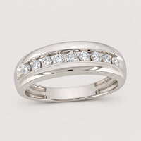 The 10k Gold Round Diamond Wedding Band 1/2 Cttw showcases seven round-cut diamonds in a channel setting with a polished split shank, offering a sophisticated and elegant choice for a wedding band—displayed on a warm off-white studio background.