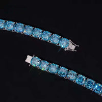 A close-up of the Blue Moissanite Tennis Bracelet-10mm in 925 sterling silver, featuring large round blue gemstones and sparkling jewels, partially unclasped and displayed against a black background.