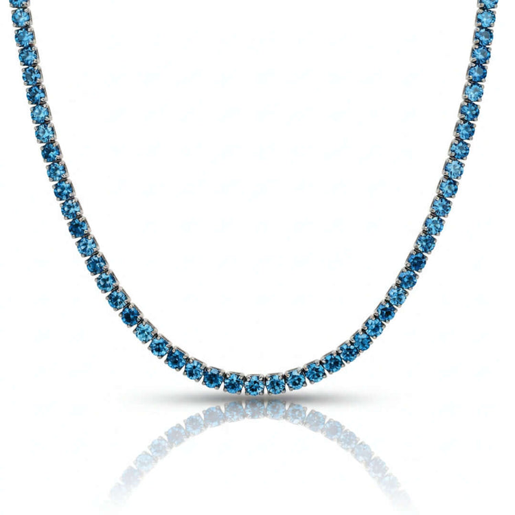 A close-up of the Blue Moissanite Tennis Chain - 10mm, showcasing a row of brilliant round blue stones set in silver or white gold, displayed against a white background.