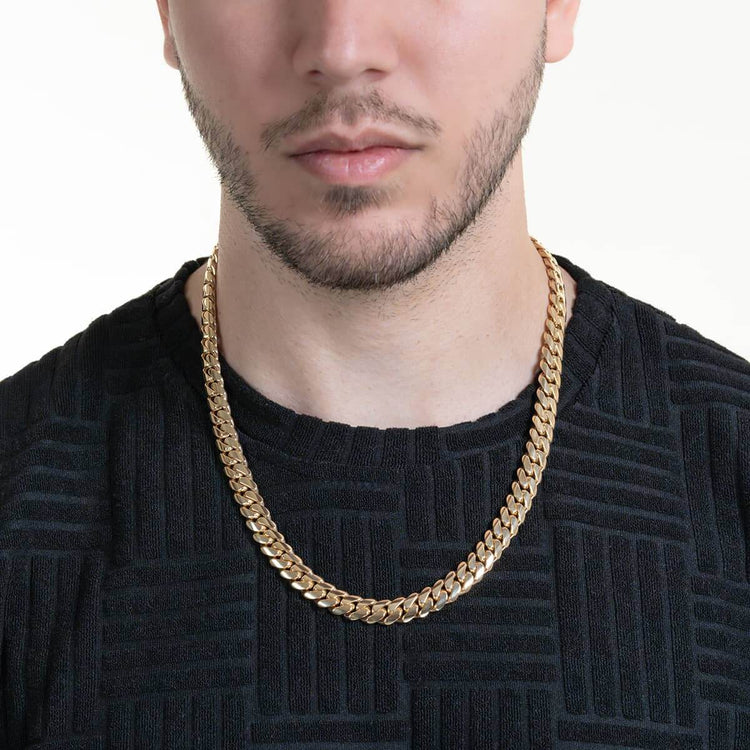 A man wearing a textured black shirt and the 10mm Handmade Miami Cuban Link Chain in solid gold (10K/14K/18K), shown from shoulders to just above the mouth, set against a plain light background.