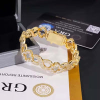 The Infinity Clover Moissanite Bracelet - 11mm features interlocking links set with sparkling stones and is shown on a black surface alongside a jewelry box, paperwork, and a certification card.