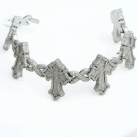 The Diamond Cross Bracelet - 10k Gold, adorned with detailed cross charms set with sparkling stones, is elegantly showcased on a white background.