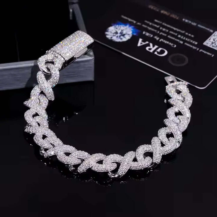 A dazzling Silver Moissanite Infinity Link Chain -13MM lies on a glossy black surface, accompanied by a certification card and a partially seen jewelry box.