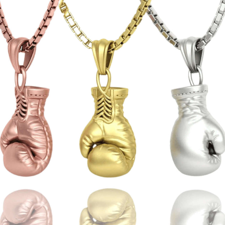 Three 14K gold boxing glove pendants for men in rose, yellow, and white gold are displayed side by side with shiny reflections—perfect as stylish men’s jewelry.