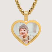 A personalized keepsake, the 14K Gold Classic Heart Picture Pendant displays a photo of a smiling baby in a striped beanie and light-colored clothes.