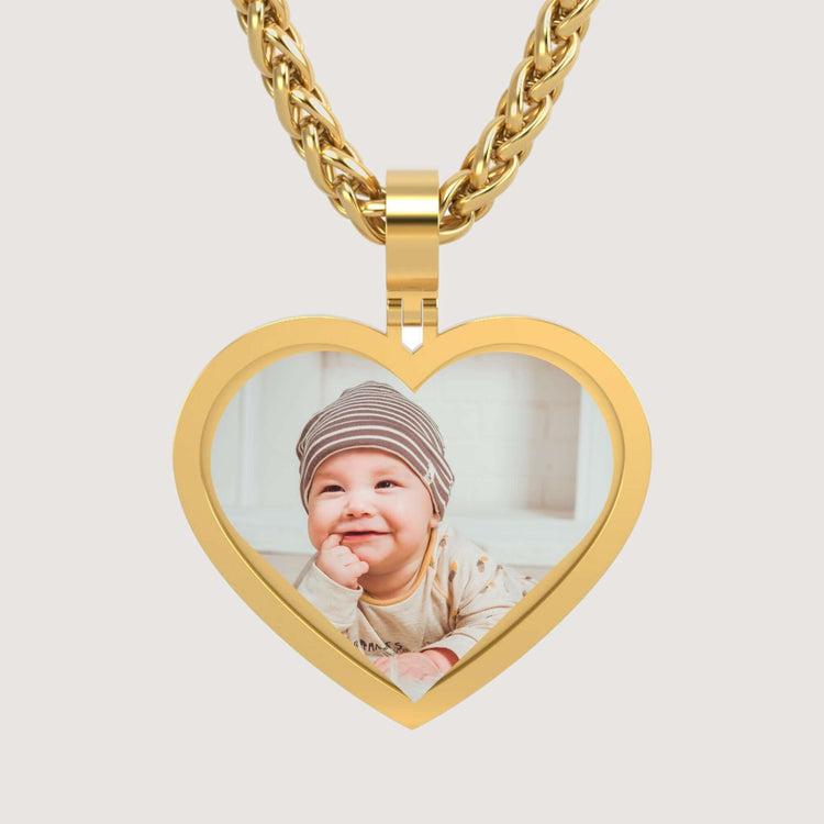 A personalized keepsake, the 14K Gold Classic Heart Picture Pendant displays a photo of a smiling baby in a striped beanie and light-colored clothes.