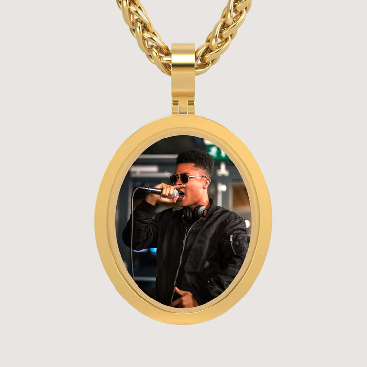 The 14K Gold Classic Oval Picture Pendant features a photo of a person in sunglasses and a black jacket singing into a microphone, headphones around their neck, elegantly set in 14K gold.