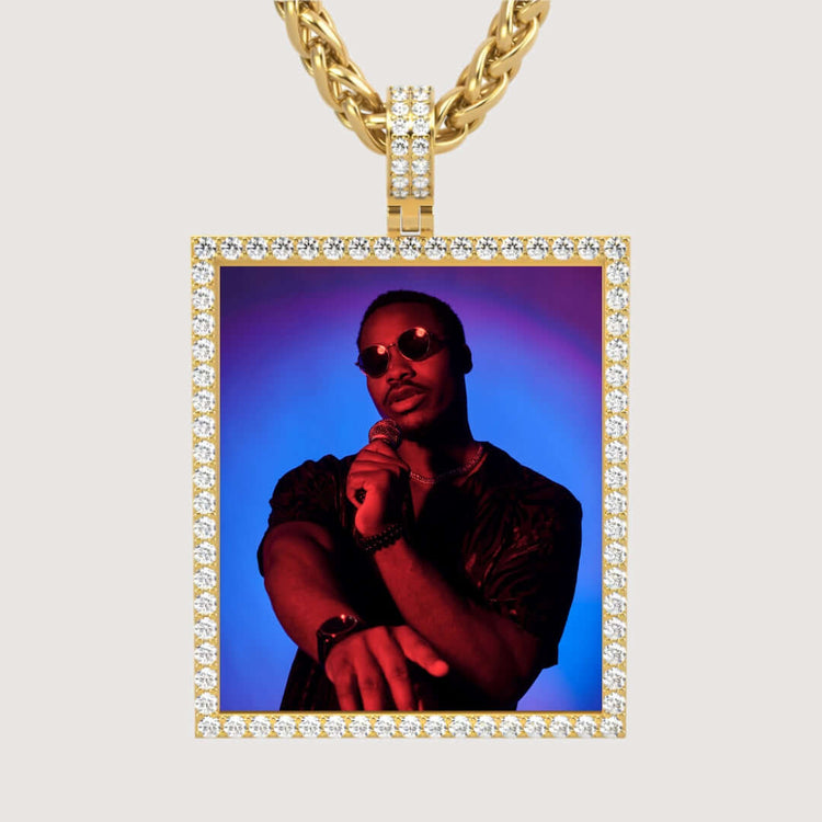 The 14k Gold Customizable Picture Pendant with Diamonds displays a framed photo of a man in sunglasses, holding a microphone, set against a blue and red gradient background.