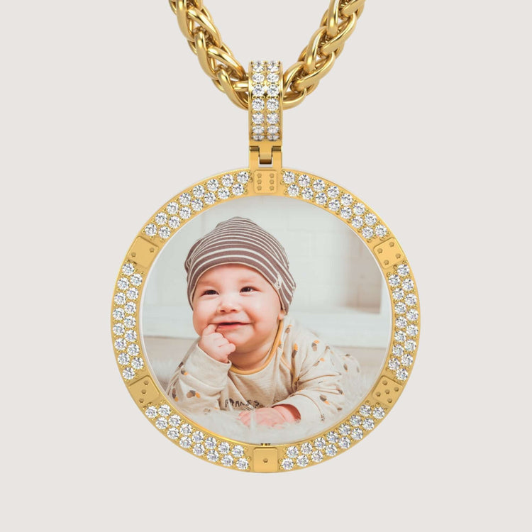 The 14K Gold Diamond-Accented Round Picture Pendant displays a round photo of a smiling baby in a striped hat and light clothes, set in 14K gold with sparkling diamond accents.