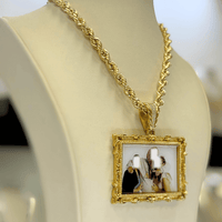 A cream-colored jewelry bust displays a 14K Gold Diamond Bail Big Frame Picture Pendant with an ornate design, featuring a blurred photo of three people on a gold rope chain necklace.