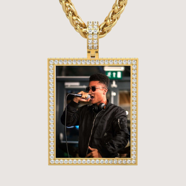 The 14K Gold Diamond Frame Rotating Photo Pendant features a young man in sunglasses and headphones performing into a mic, set in a rectangular diamond-framed design on a thick gold chain against a plain background.