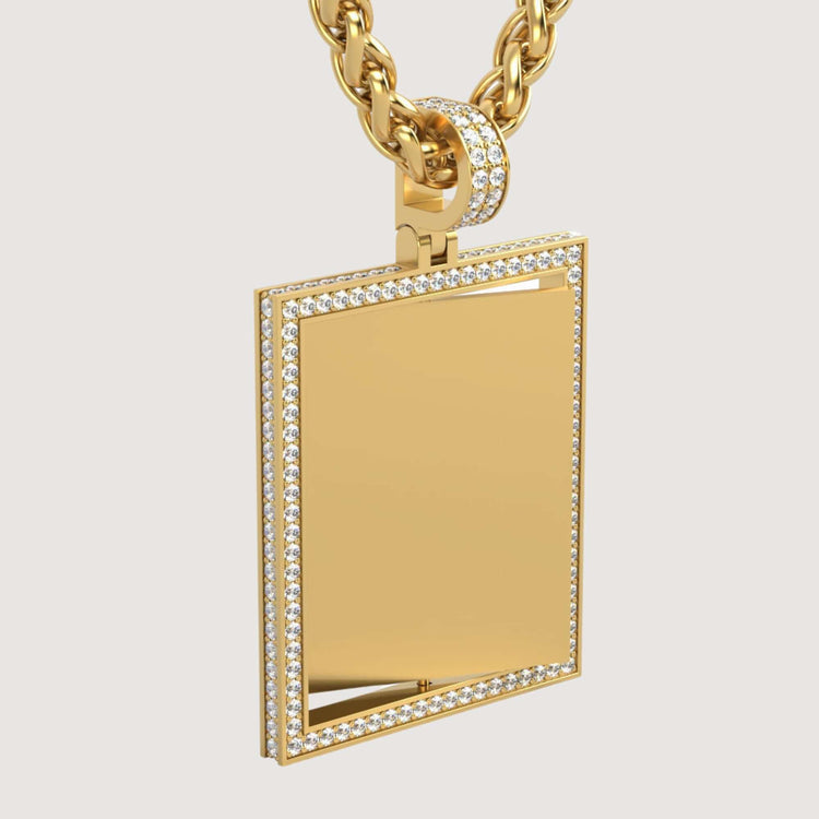 The 14K Gold Diamond Frame Rotating Photo Pendant features a smooth, modern design with a sparkling diamond-studded border and hangs from a thick gold chain, creating an elegant effect against the plain light background.