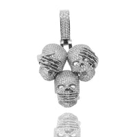 The 14k Hear No Evil, See No Evil, Speak No Evil Pendant features three skulls with mouths covered by bars and sparkling stones, finished with a diamond-studded bail at the top.