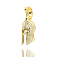 The Half-Face Diamond Spartan Helmet Pendant in 14K Gold features a helmet design adorned with sparkling white stones, displayed against a white background with a subtle reflection beneath.