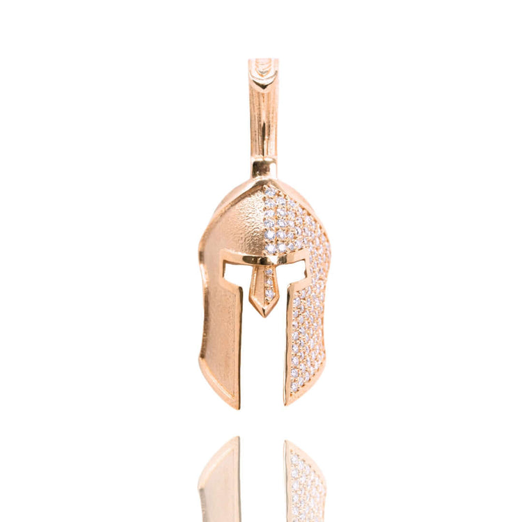The Half-Face Diamond Spartan Helmet Pendant in 14K gold features a Greek warrior helmet design with sparkling stones on one side, shown against a white background.