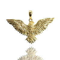 The 14k Yellow Gold Eagle Pendant features finely detailed feathers and outstretched wings, displayed on a white background with a subtle reflection—an elegant piece for any eagle jewelry collection.