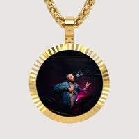 The 14K Gold Fluted Round Picture Pendant displays a photo of a singer in a recording studio and hangs from a thick gold chain, creating an elegant keepsake against a plain background.
