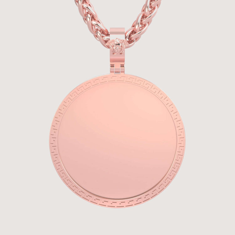 The 14K Gold Greek Key Round Picture Pendant features a subtle Greek key border and hangs from a twisted rose gold chain, displayed against a simple light background.
