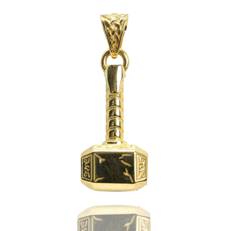 The 14k Solid Gold Hammer Pendant features engraved patterns on the head and handle, shown against a white background with a subtle reflection—ideal for fans of craftsmanship-inspired jewelry.