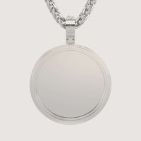 A close-up of the 14K Gold Modern Double Border Round Picture Pendant, blank and shiny, hanging from a thick twisted chain against a plain light background.