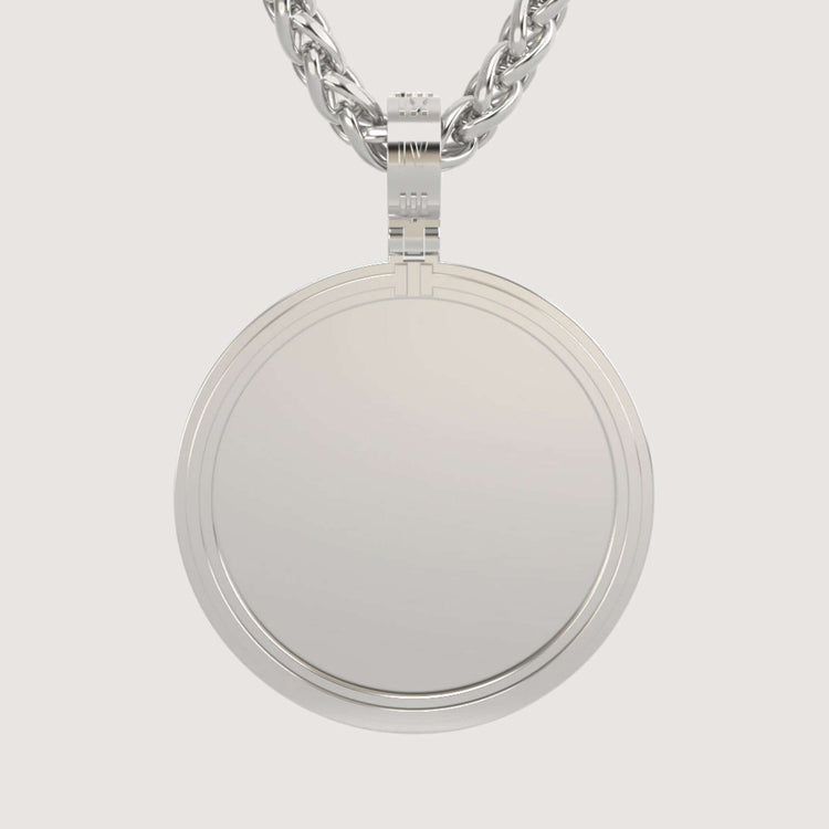 A close-up of the 14K Gold Modern Double Border Round Picture Pendant, blank and shiny, hanging from a thick twisted chain against a plain light background.