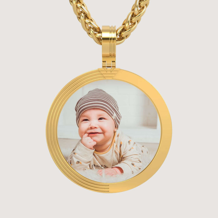 The 14K Gold Modern Grooved Round Picture Pendant displays a cherished baby photo in a stylish setting, elegantly hung on a matching chain.