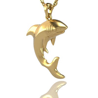 The 14k Gold Shark Pendant is shown hanging from a matching chain against a white background, with a subtle reflection beneath it.