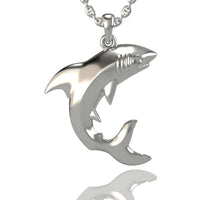 The 14k Gold Shark Pendant features a stylized shark with smooth curves, detailed fins, tail, and gills. Crafted in 14K gold and shown on a sleek chain against a white background with a faint reflection, it's an elegant piece of jewelry.