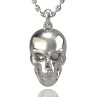 A 14k Gold Skull Pendant with detailed facial features—including eye sockets, nose, and teeth—hangs vertically on a chain against a plain white background, its polished surface reflecting light.