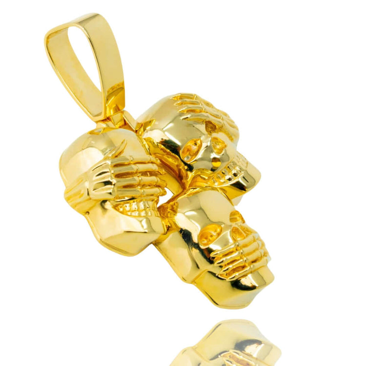 The Hear No Evil, See No Evil, Speak No Evil Gold Pendant is a shiny 14K gold piece featuring three skulls with skeletal hands covering their eyes, ears, and mouth—symbolizing see no evil, hear no evil, speak no evil.